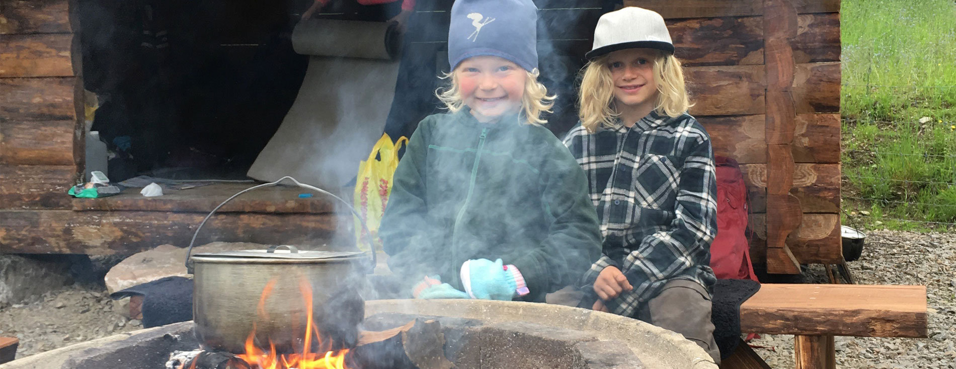 Barn vid eld framför vindskydd på Kungslederna